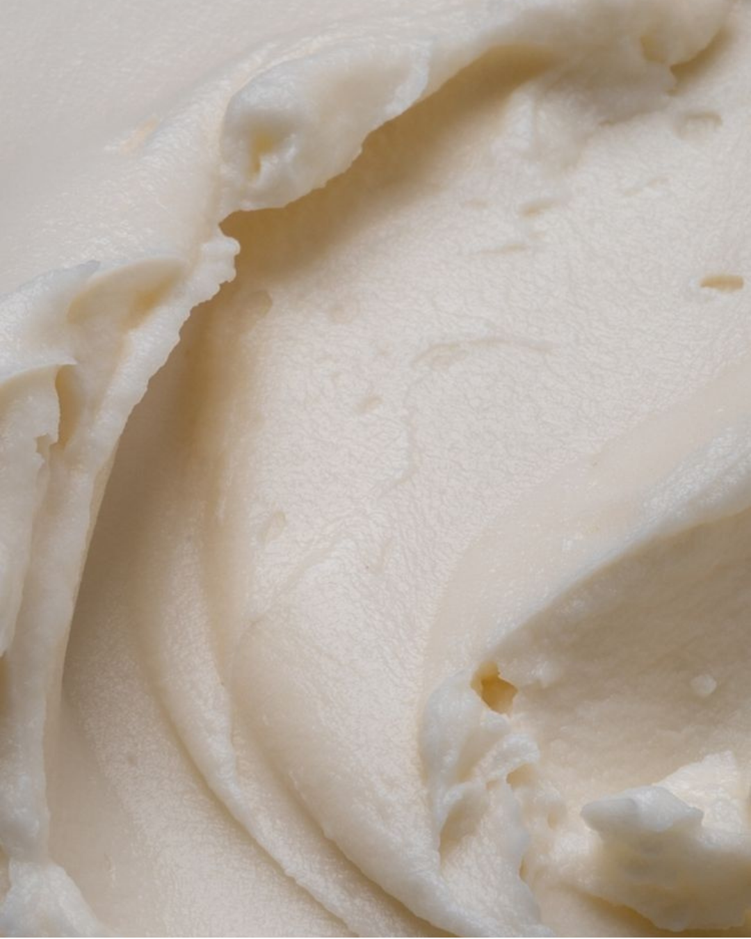 Close-up of a rich, whipped cream texture with soft peaks and natural folds.